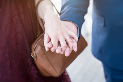 女性と男性が手を繋いでいる画像