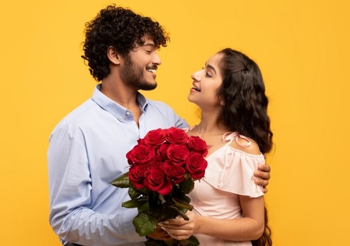 男性が女性に花束を渡している画像