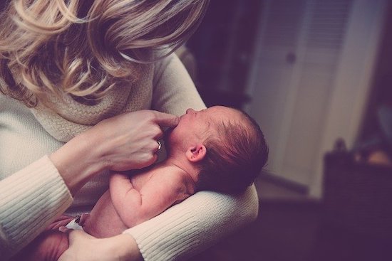 赤ちゃんをあやしている女性の画像