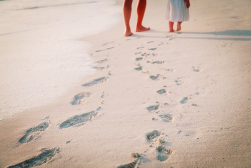 砂浜を歩いている男女の画像
